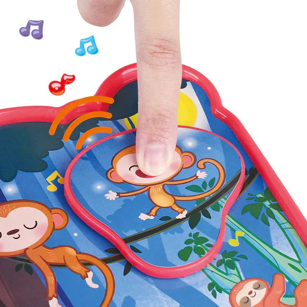 Colorful monkey toy with a hand pressing a button on a white background