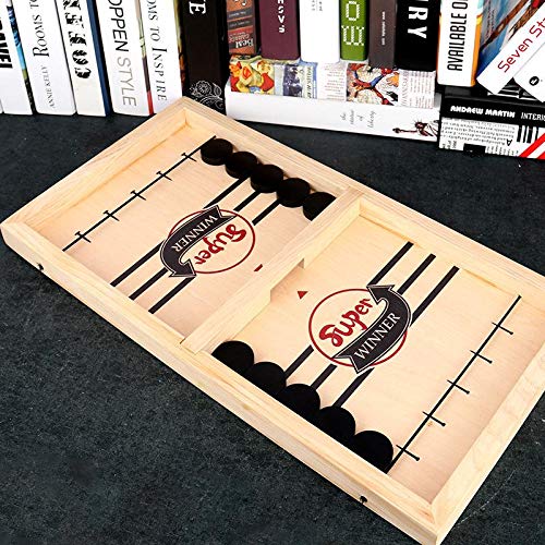 Wooden game board with darts labeled 'Super Winner' on a dark surface with books in the background.