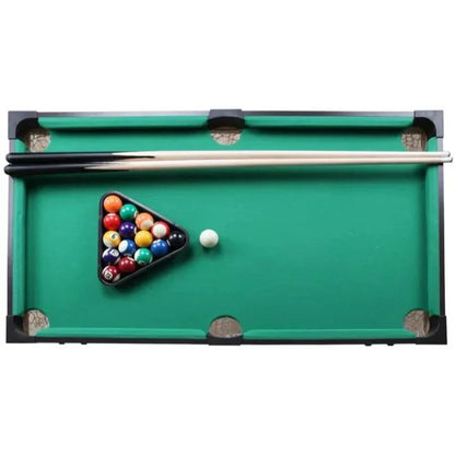 Miniature pool table with balls and a cue on a white background